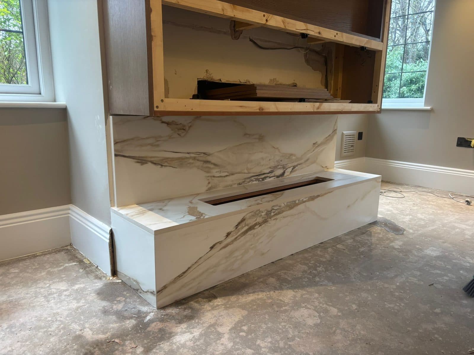 The book-matched marble fireplace surround being installed