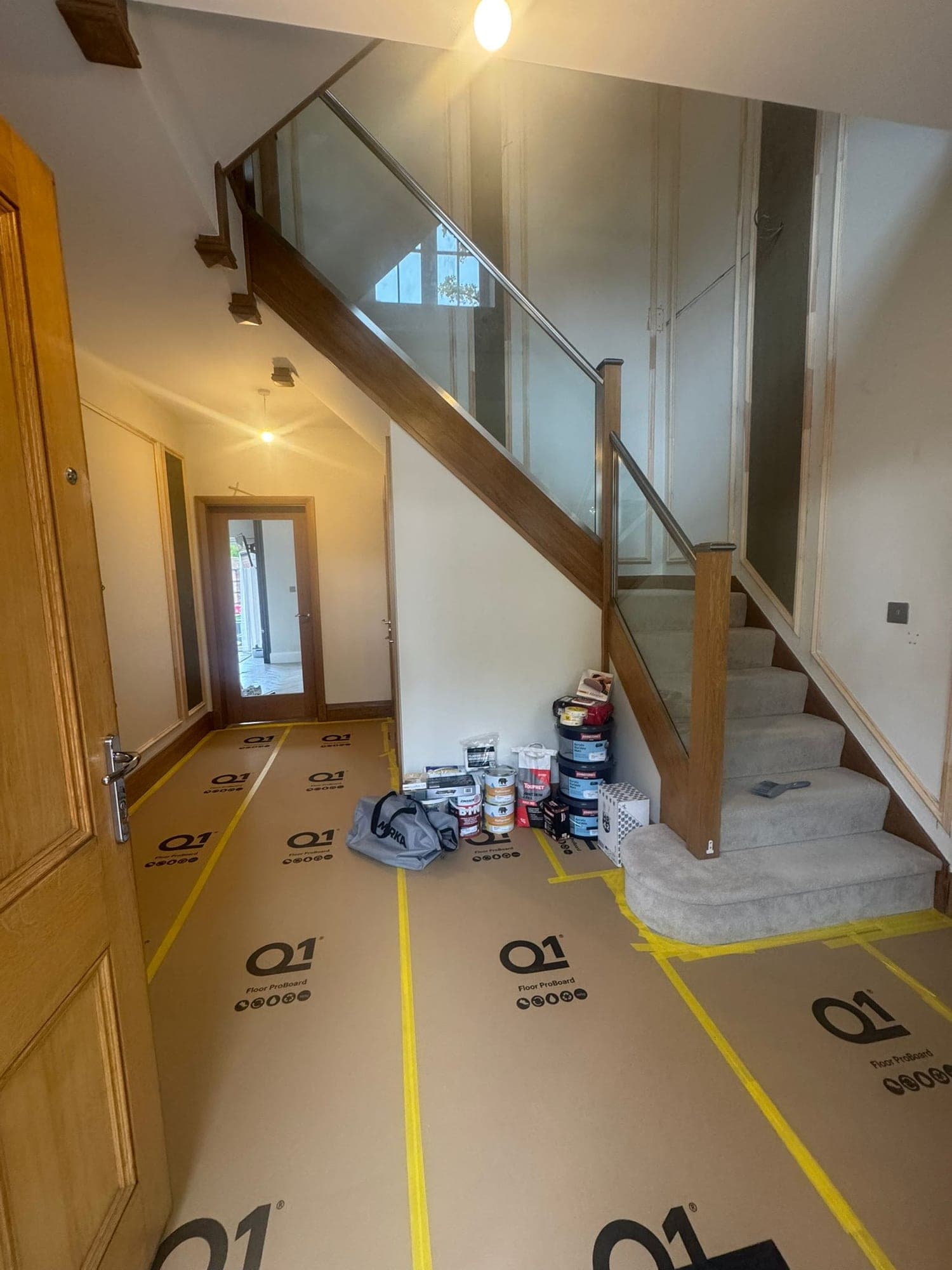 The entrance hall and staircase before the renovation, with floor protection down