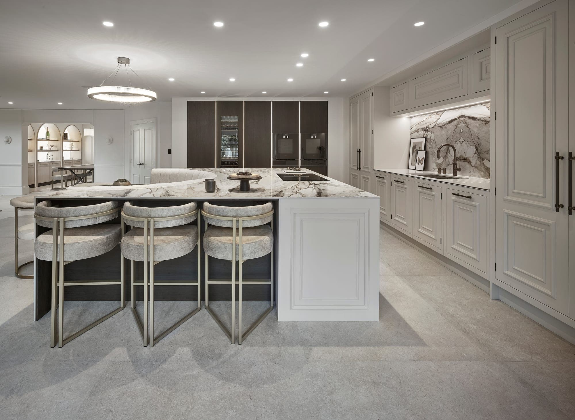 A luxury open-plan kitchen with a marble island and breakfast bar in a Prestbury home, Cheshire