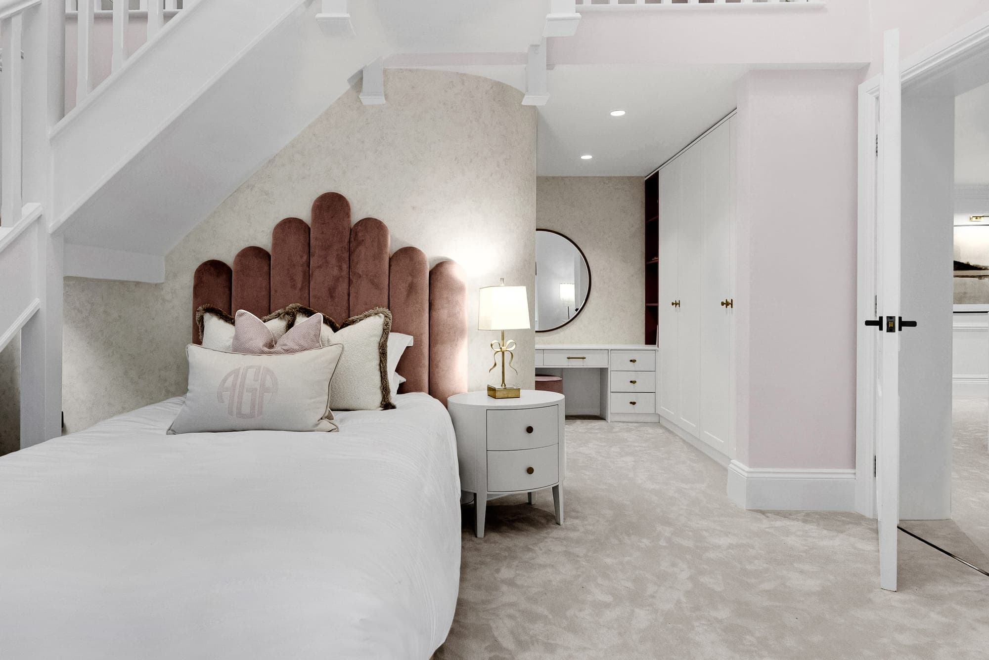 An elegant bedroom with a scalloped velvet headboard and a bespoke dressing area in a Prestbury home, Cheshire