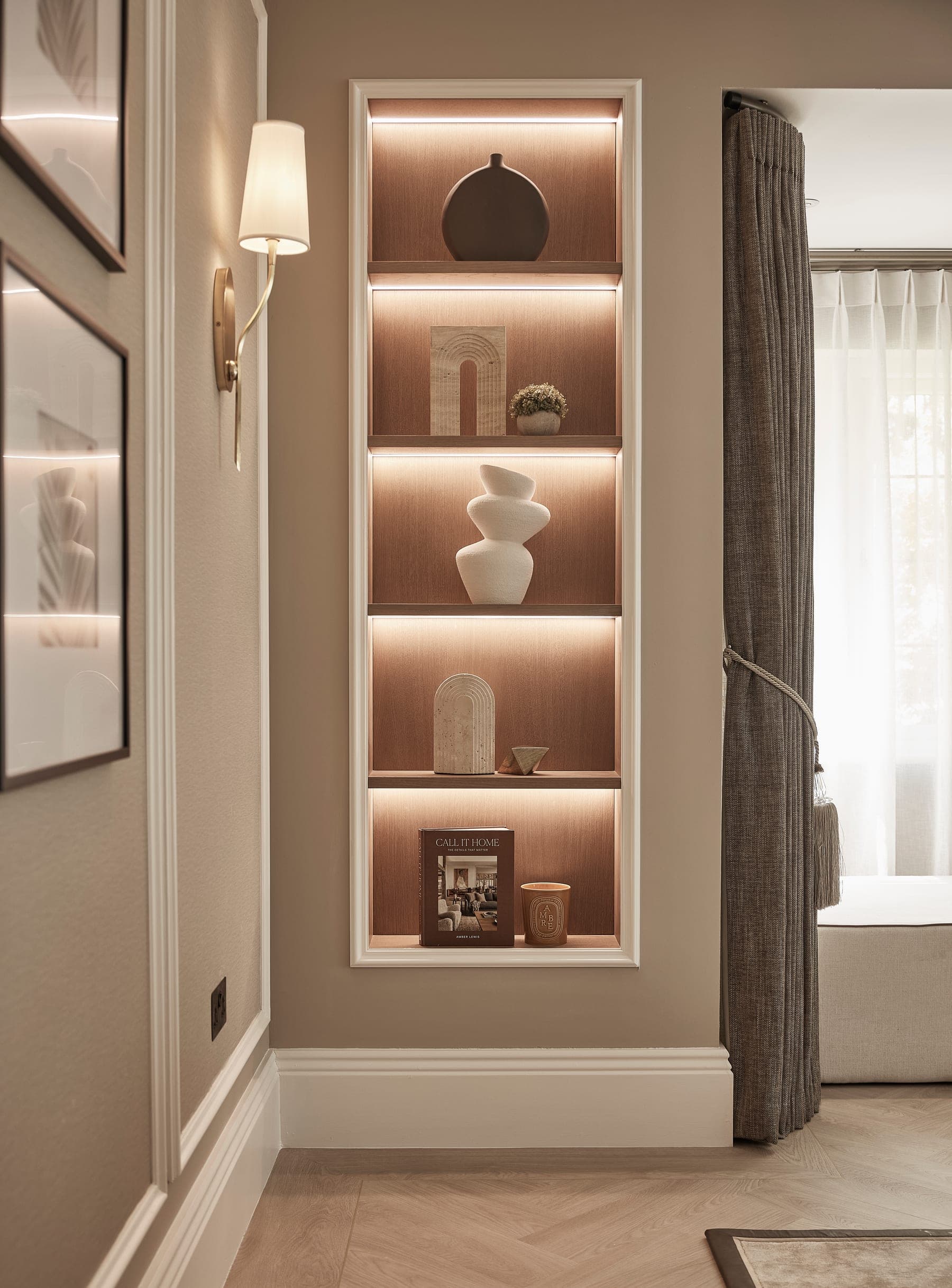 A backlit bespoke alcove with styled shelving in a Cheshire home