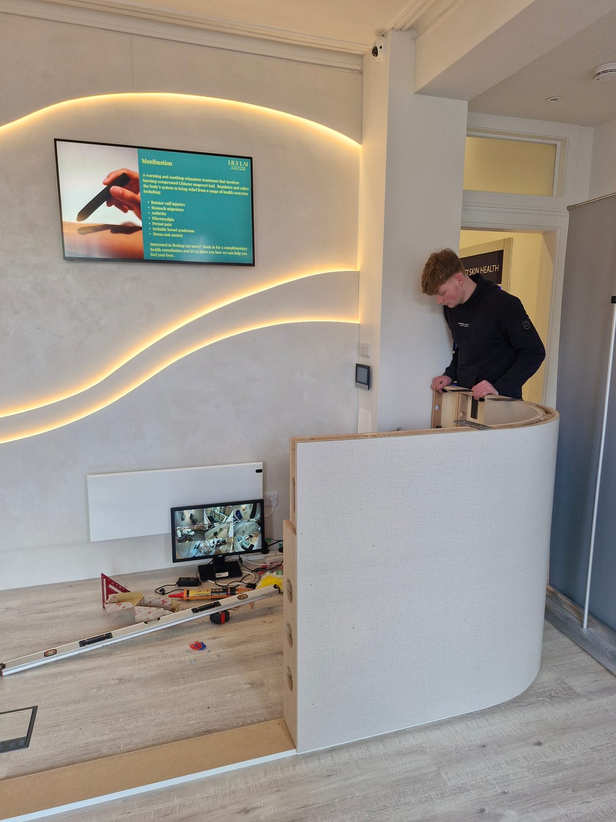 Fitting the curved reception desk by the backlit feature wall