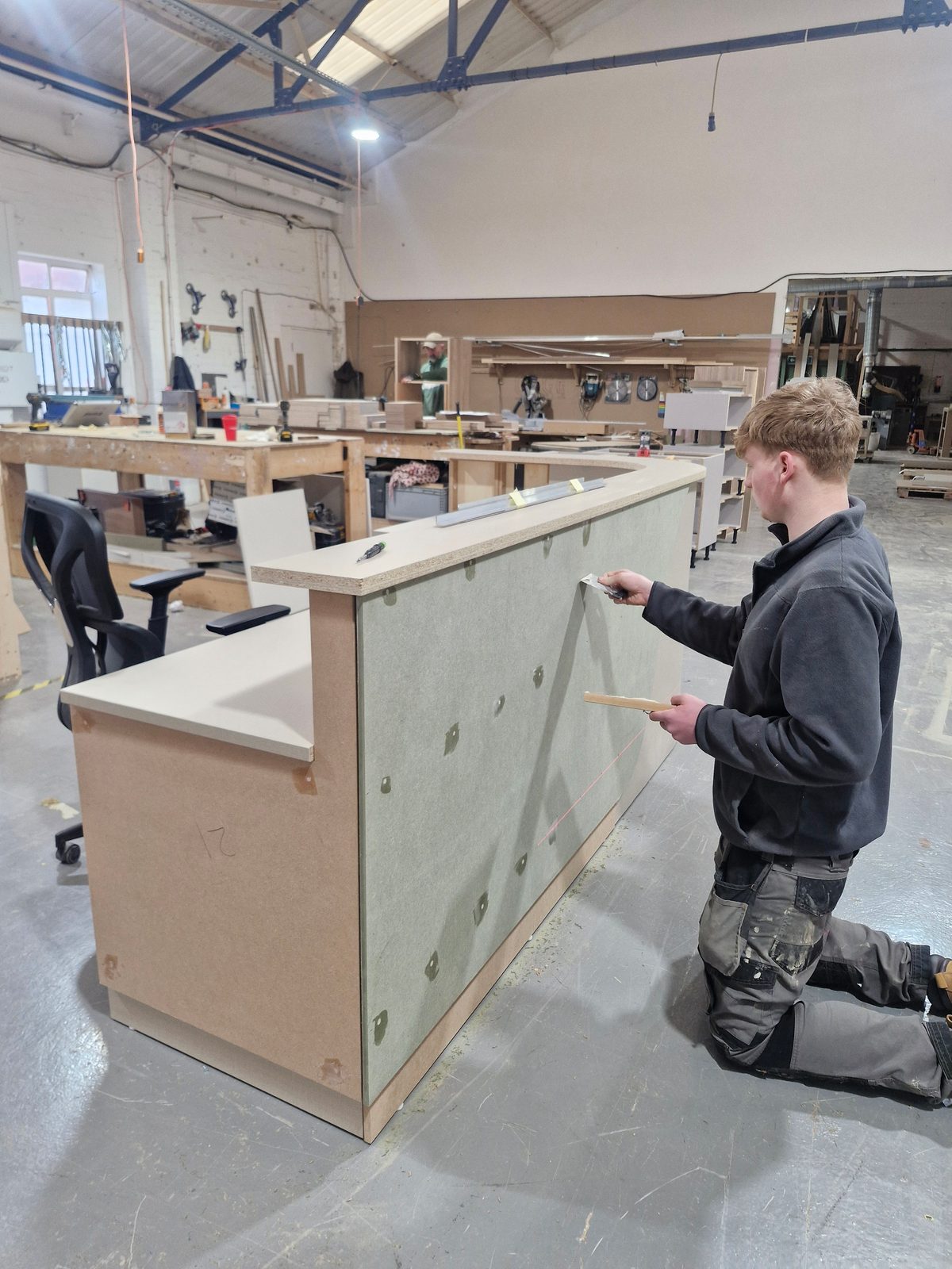 The curved reception desk under construction in the workshop