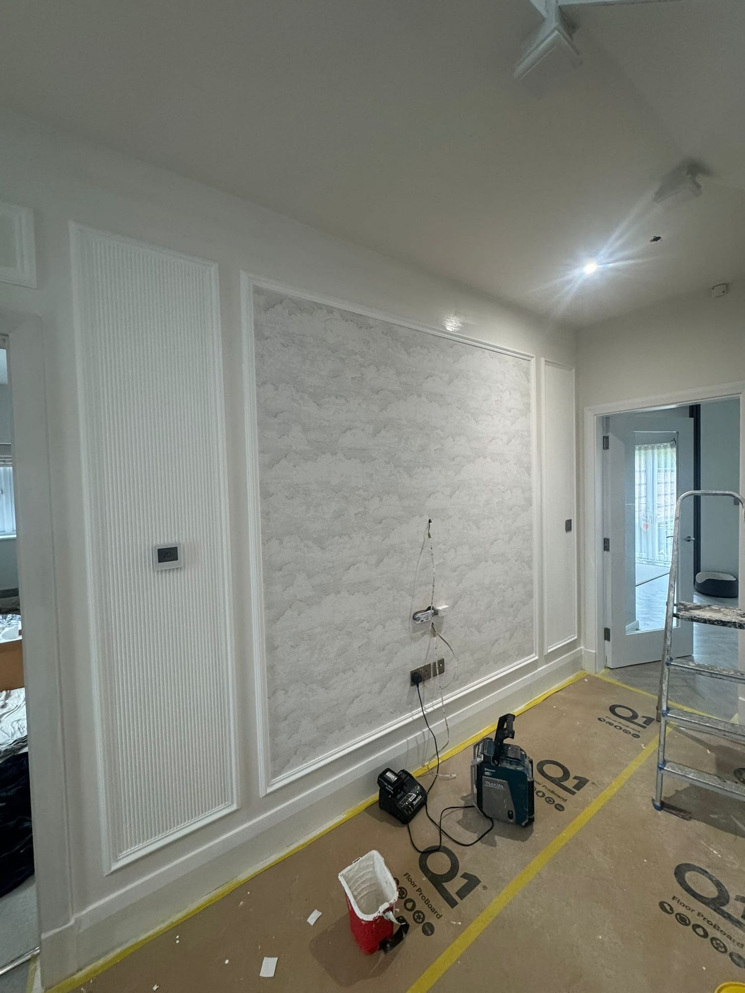 New wall panelling and a textured plaster panel being installed during the renovation