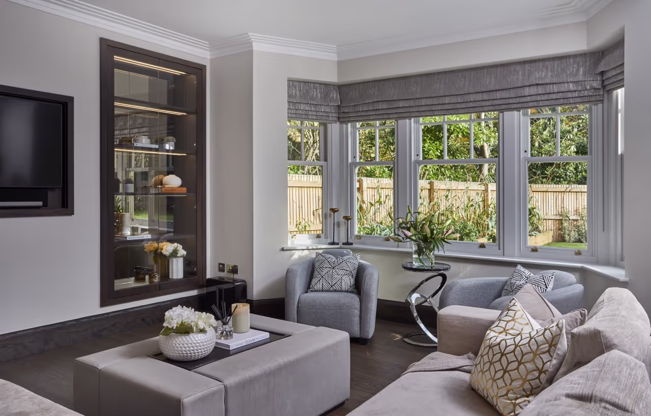 A bay-window sitting area with a bespoke display cabinet in a Cheshire home