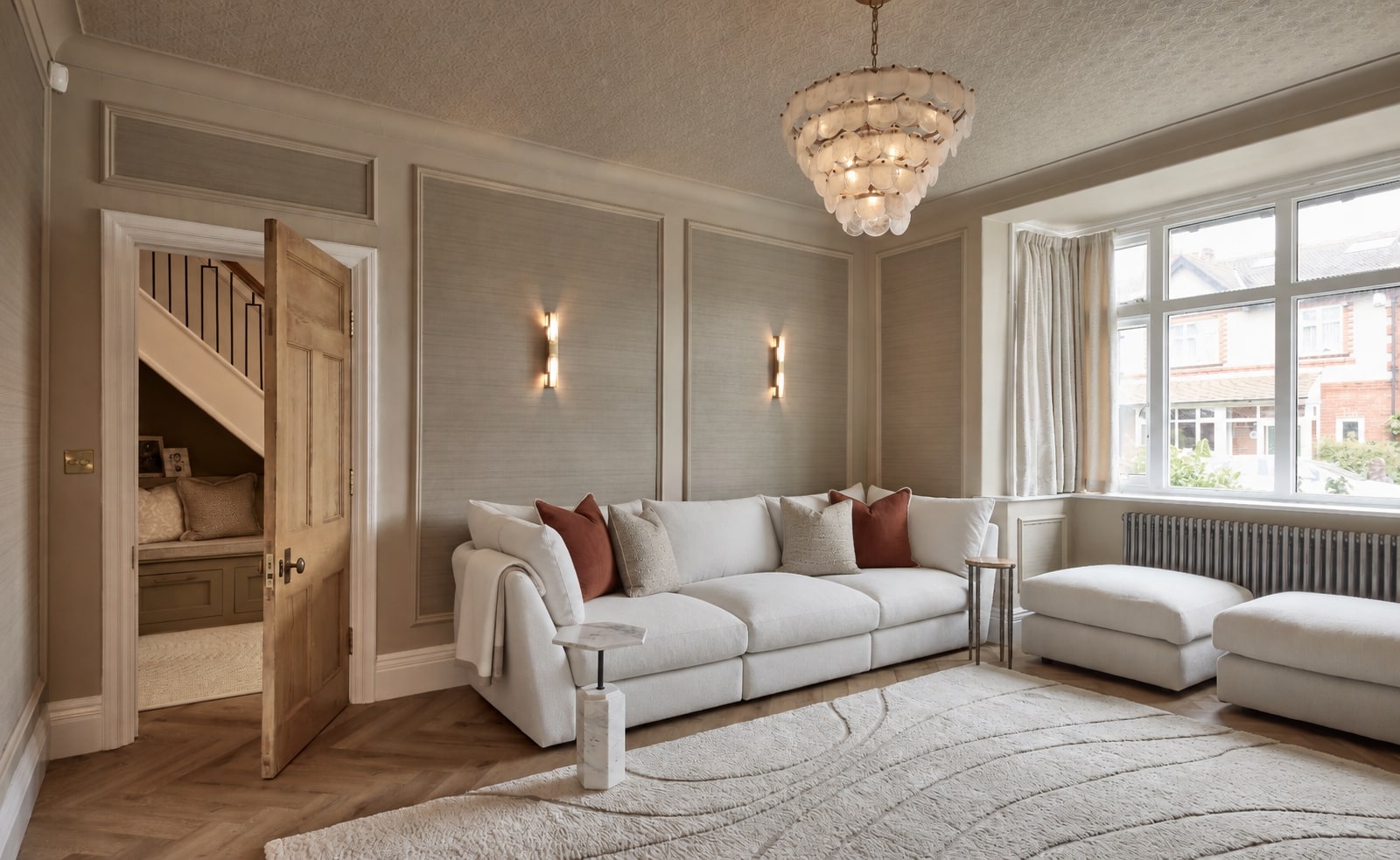 A warm sitting room with wall lights and a tonal, textured palette