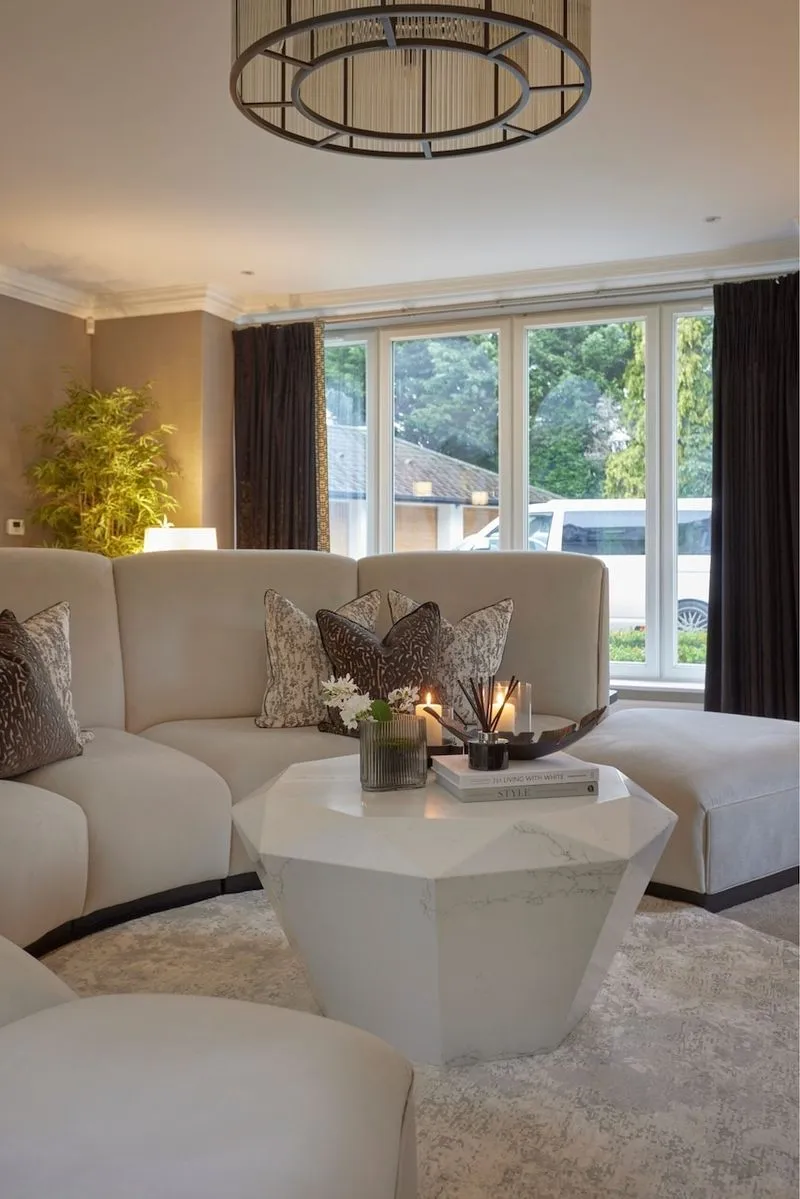 Curved cream sofas around a marble coffee table in a Knutsford home