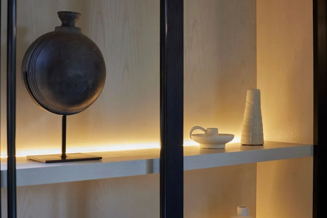 A backlit niche framing a sculptural vessel