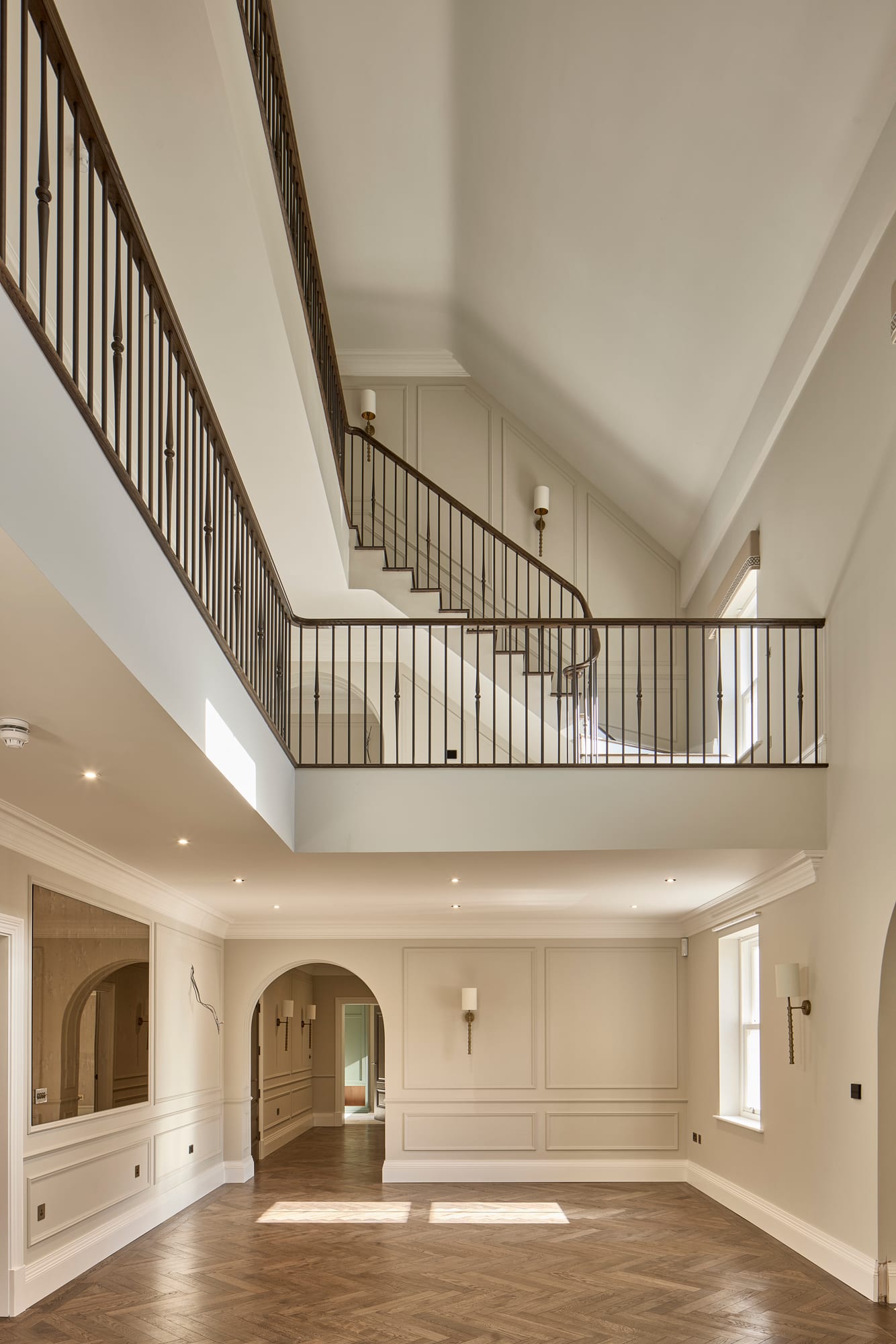 A generous, double-height hall with a sweeping staircase in a new build